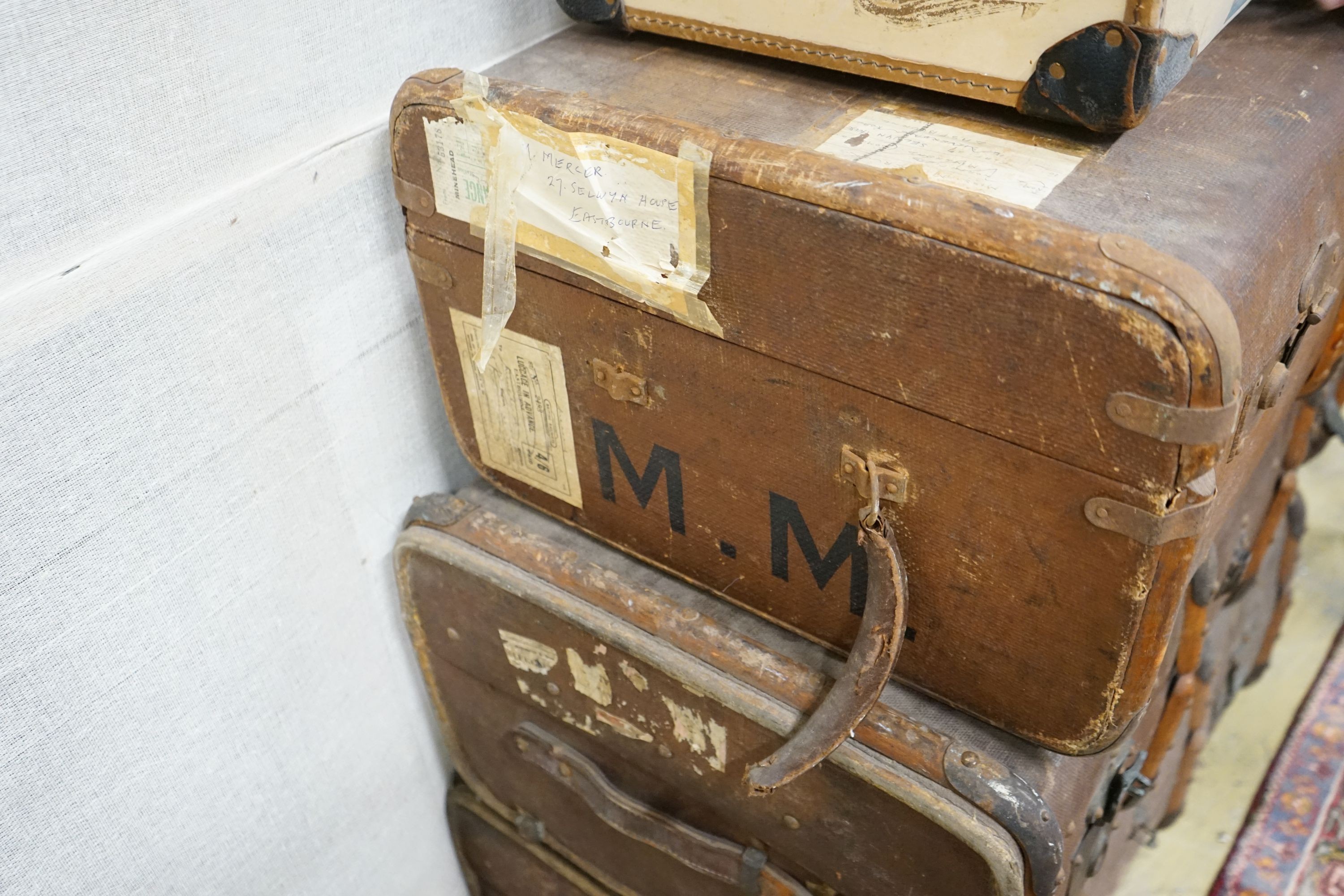 A collection of five vintage suitcases, largest width 83cm